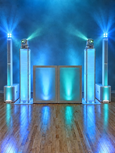 The Majestic Experience setup: white booth, column speakers, moving-head lights, and teal uplighting